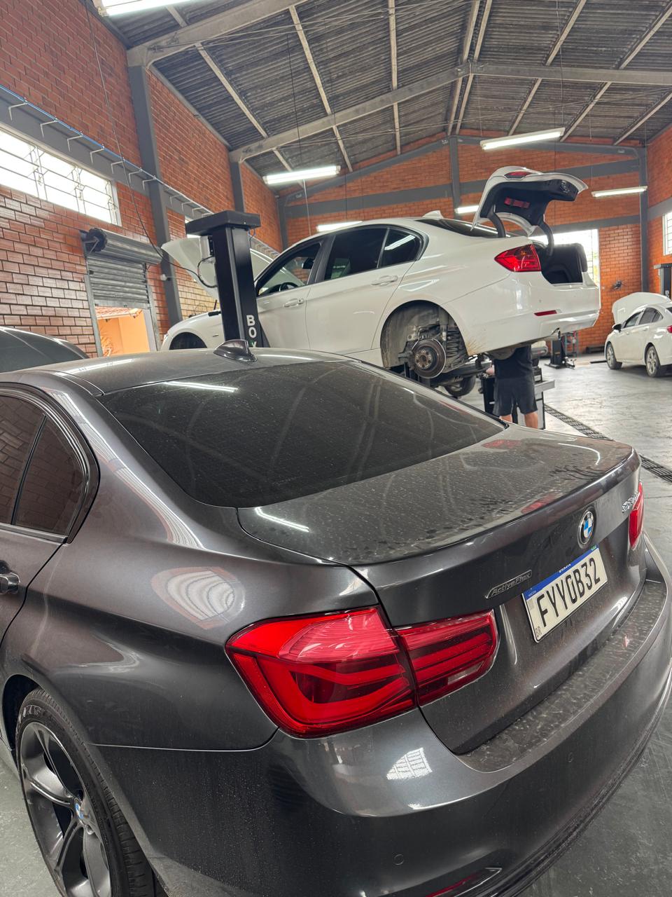 Veículos BMW na oficina Testoni, um deles no elevador